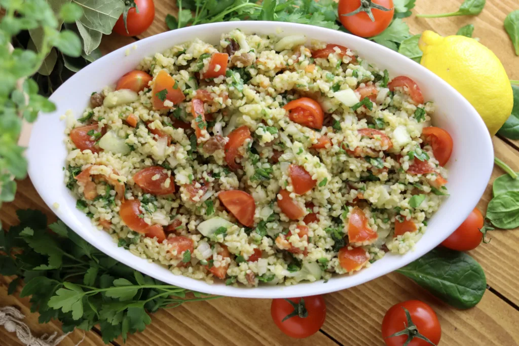 image showing taboule oriental salad with raisins and cherry tomatoes in the background
